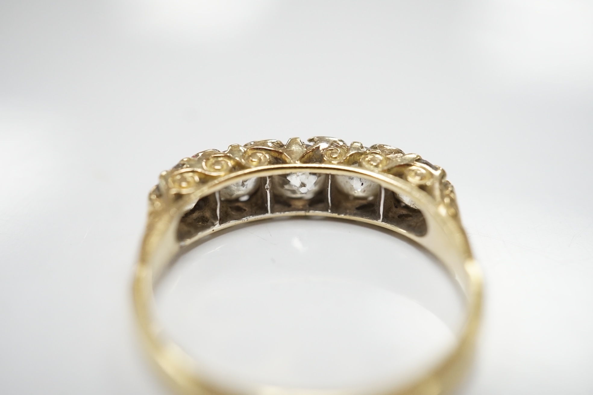 An early 20th century 18ct and graduated five stone diamond set half hoop ring, with rose cut diamond set spacers, size Q/R, gross weight 4 grams. Condition - poor to fair